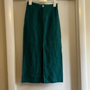 Paloma wool linen skirt with pearl button + front slit. Hits above ankle.